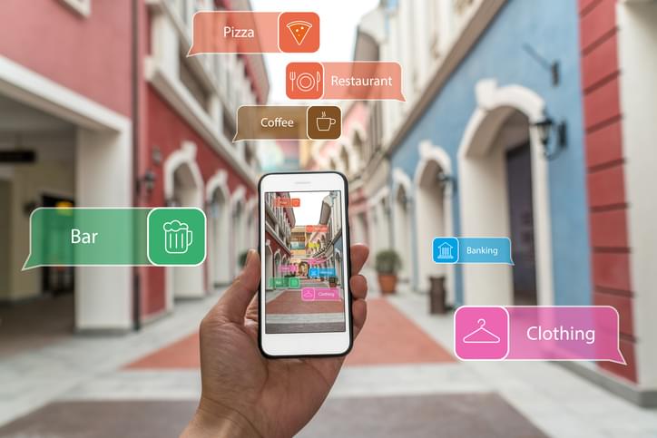 Augmented reality marketing street. Hand holding smart phone use AR application to check information