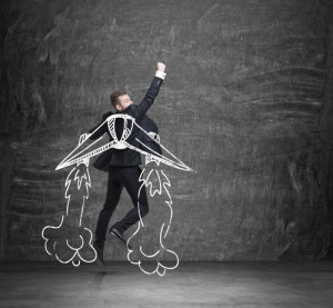 A concept of business angel. A businessman is flying over the black chalkboard.